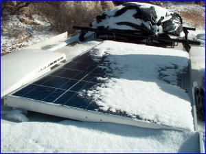 Panel in snow, and with the shadow of the satellite dish